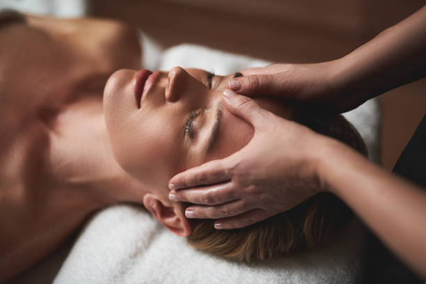 Especialista aplicando masaje Kobido en Quironatura Torrox con movimientos rítmicos en el rostro de una persona, combinando relajación profunda con un efecto lifting natural.